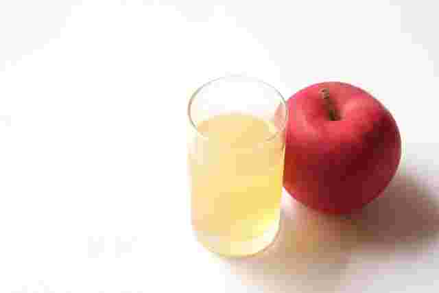 コップ1杯のりんごジュースと赤いりんご1個