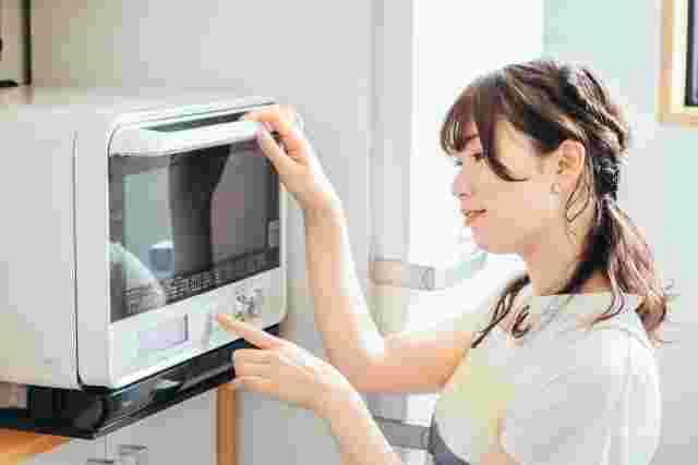 電子レンジを操作する女性