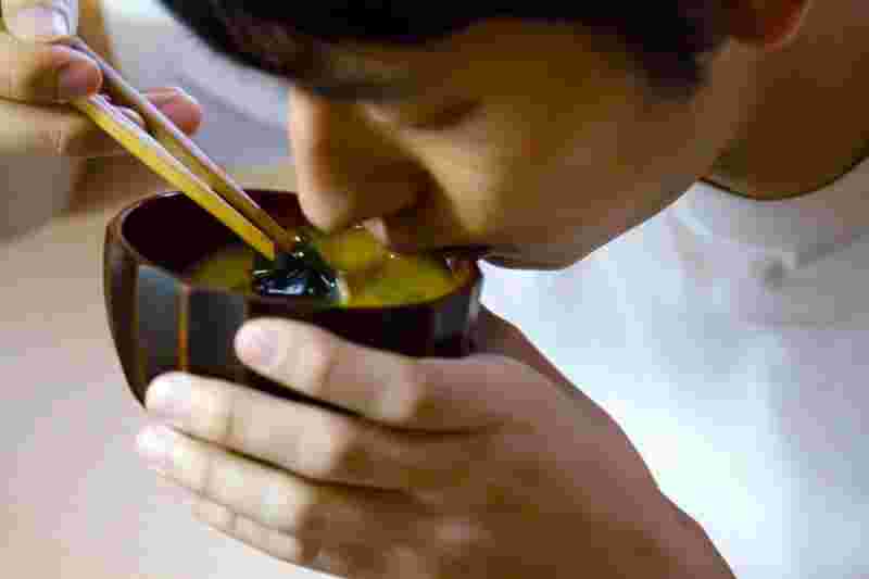 味噌汁を食べる男性